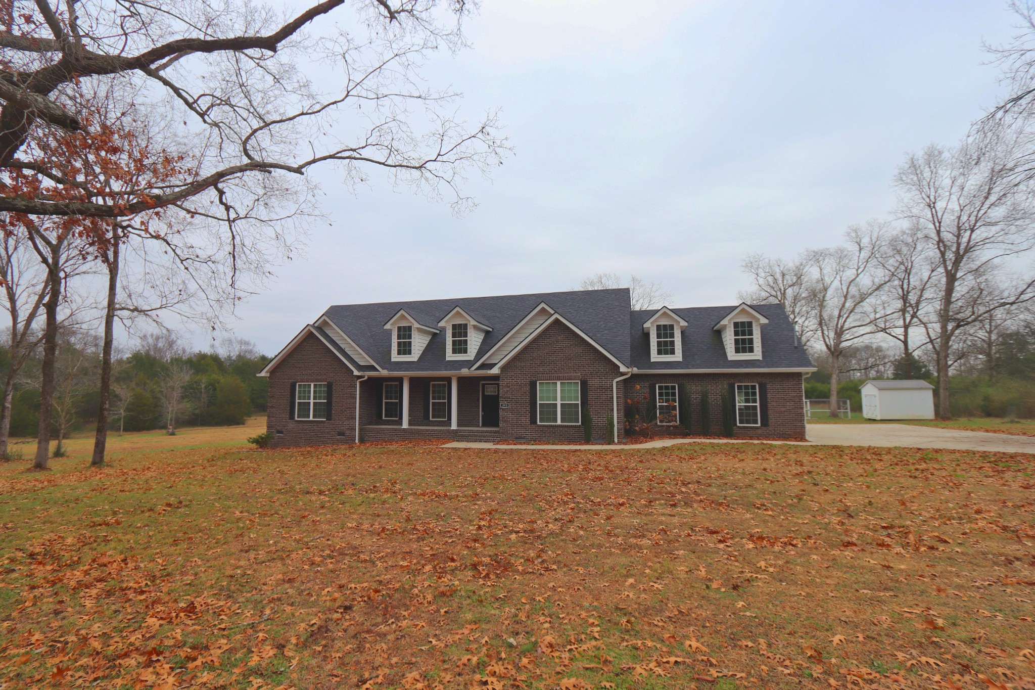 395 Harrison Road Shelbyville, TN 37160 - Photo 2 of 30 a front view of a house with a yard covered in snow