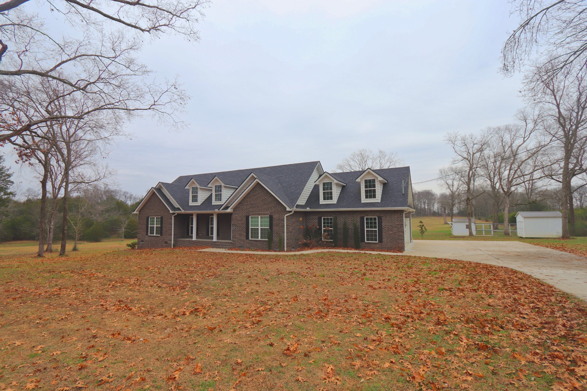 395 Harrison Road Shelbyville, TN 37160 - Photo 3 of 30 a front view of a house with a yard covered with snow