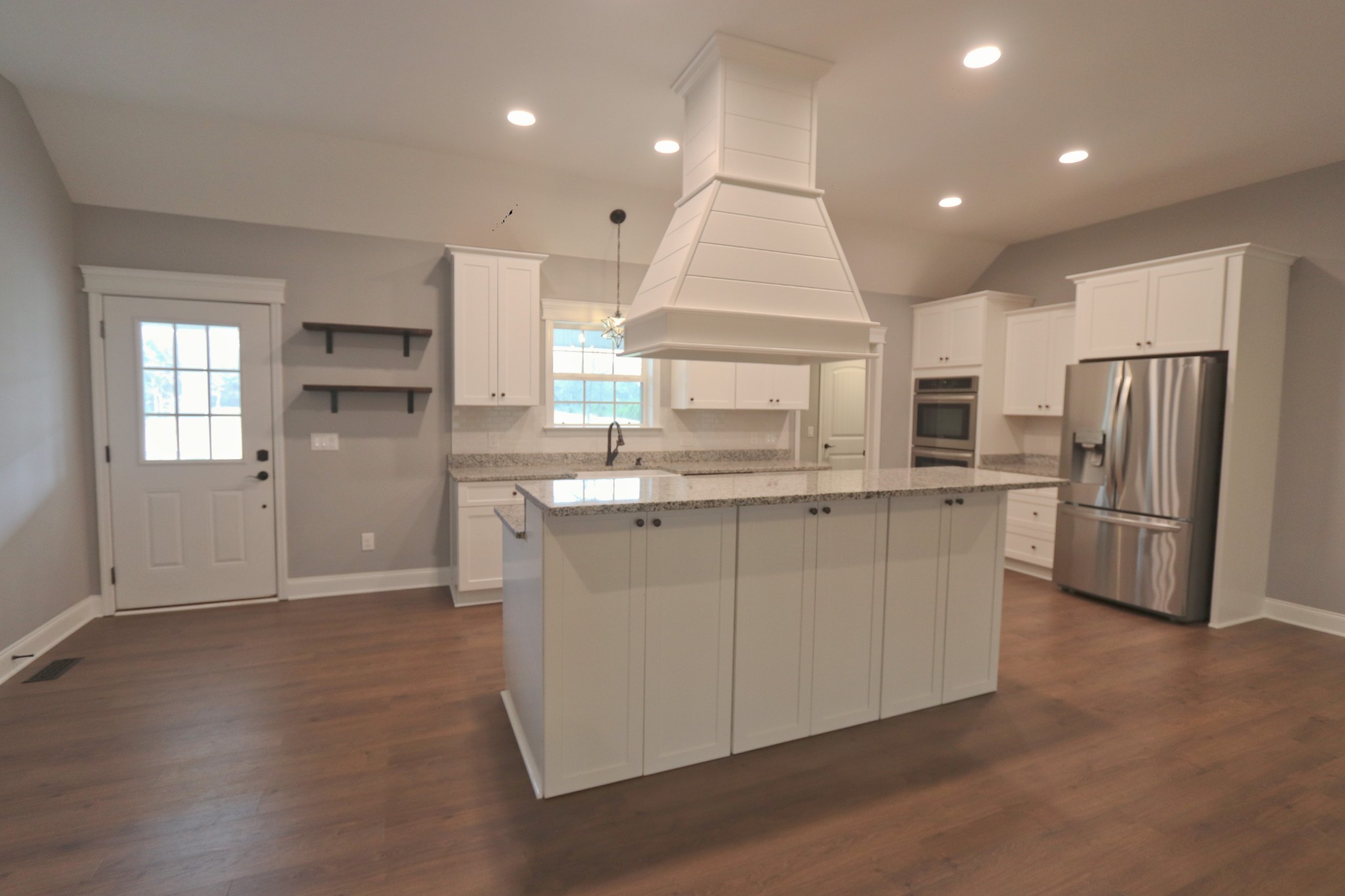395 Harrison Road Shelbyville, TN 37160 - Photo 10 of 30 a kitchen with stainless steel appliances granite countertop a refrigerator a sink dishwasher a stove and a refrigerator with wooden floor