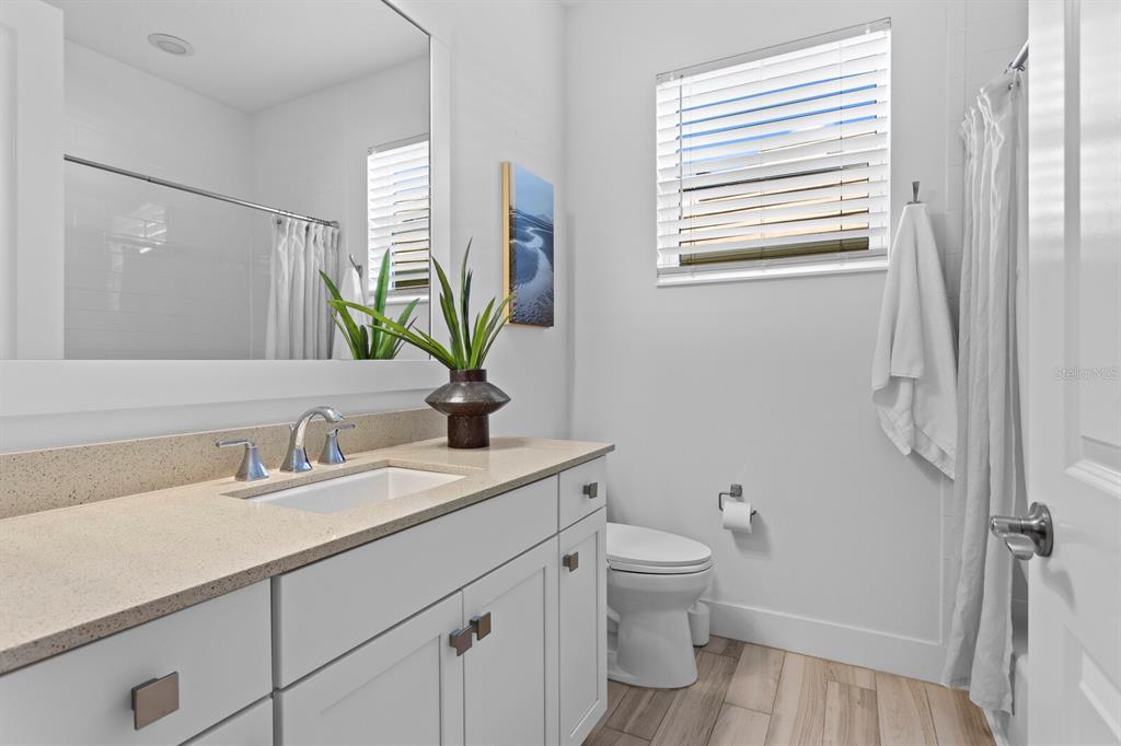 8057 Tidal Pointe Way Sarasota, FL 34240 - Photo 20 of 27 a bathroom with a granite countertop sink toilet and a mirror