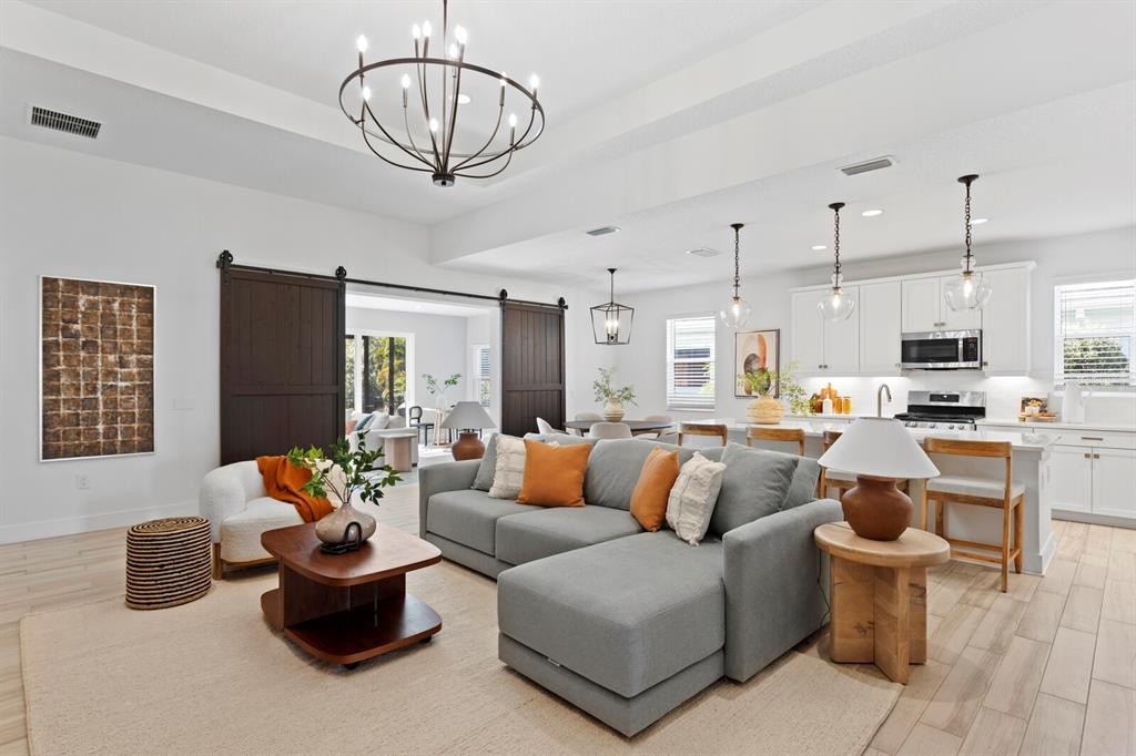 8057 Tidal Pointe Way Sarasota, FL 34240 - Photo 5 of 27 a living room with furniture kitchen view and a chandelier
