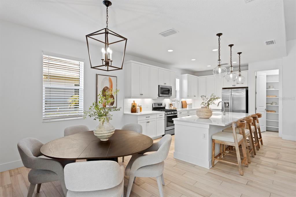 8057 Tidal Pointe Way Sarasota, FL 34240 - Photo 7 of 27 a dining room with wooden floor a chandelier a wooden table and chairs