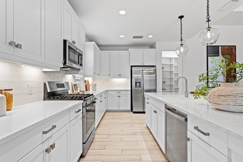 8057 Tidal Pointe Way Sarasota, FL 34240 - Photo 9 of 27 a kitchen with stainless steel appliances kitchen island granite countertop a sink and cabinets