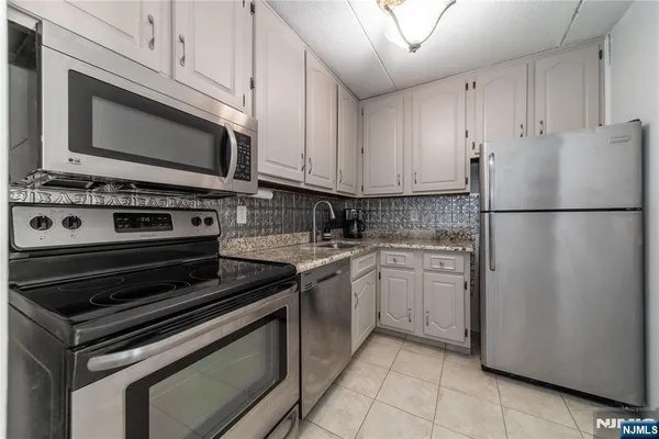 a kitchen with a refrigerator sink and cabinets