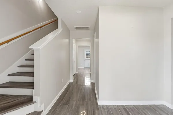 a view of a hallway with wooden floor and entryway