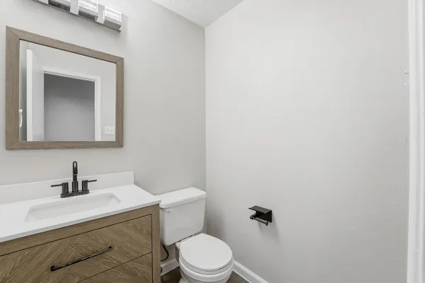 a bathroom with a toilet a sink and mirror