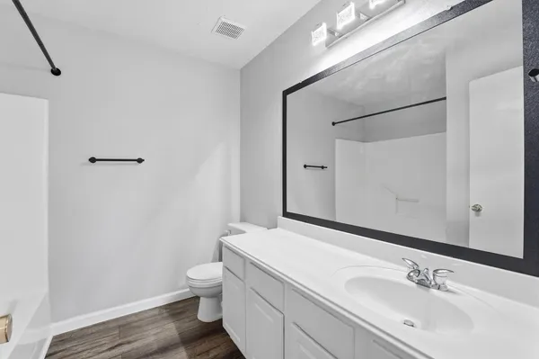 a bathroom with a sink a toilet and a large mirror
