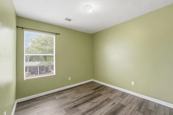 a view of a room with wooden floor and windows