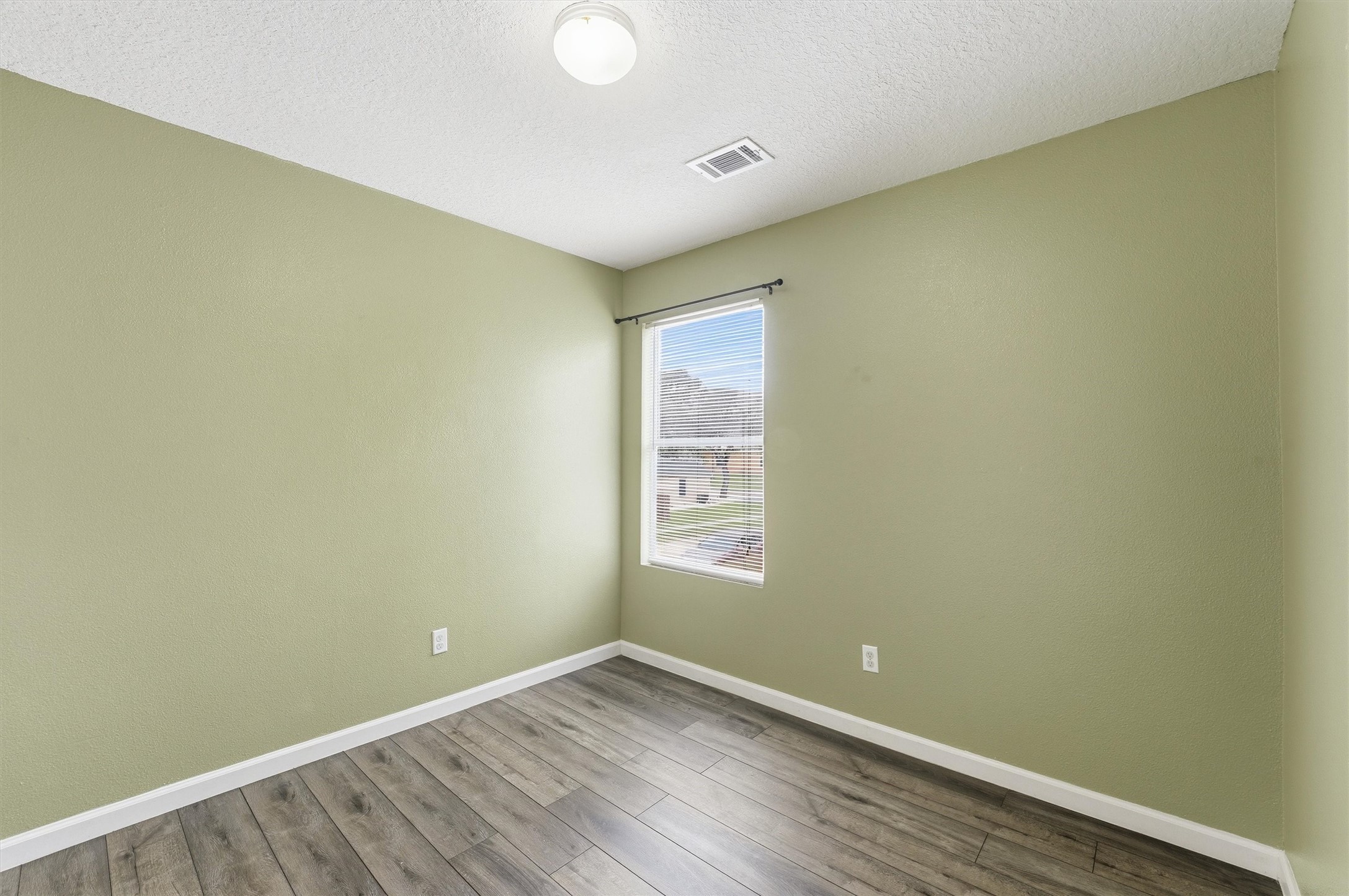 15403 Apple Bloom Way Channelview, TX 77530 - Photo 16 of 25 an empty room with wooden floor and windows