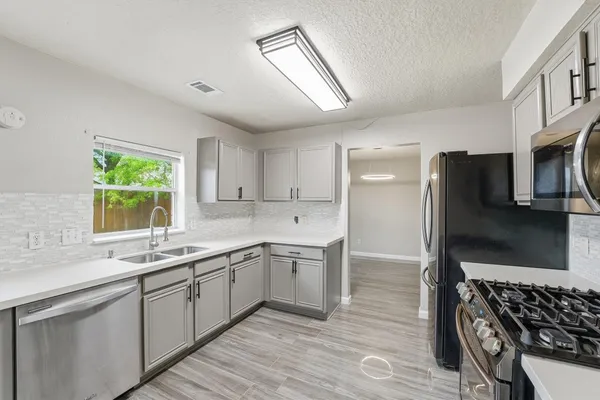 a kitchen with stainless steel appliances kitchen island granite countertop a sink stove and refrigerator