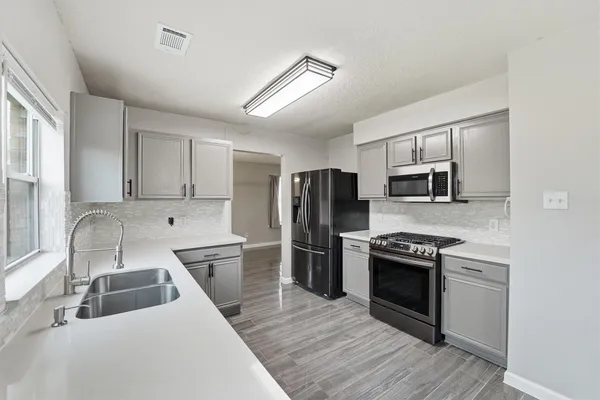 a kitchen with stainless steel appliances granite countertop a sink stove and refrigerator