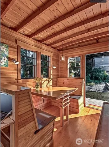 a view of a patio with table and chairs with wooden floor and fence