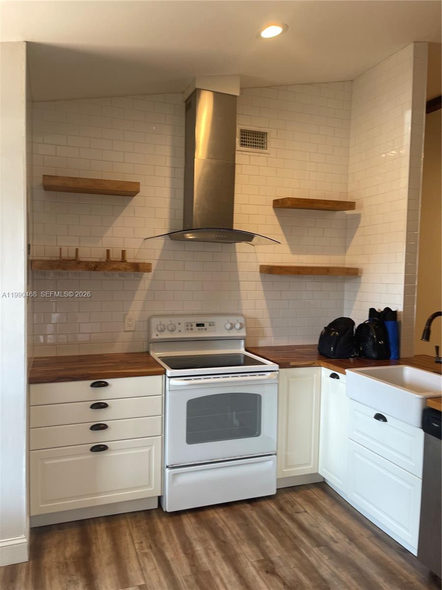 11269 Southwest 116th Terrace, Unit 11269 Miami, FL 33176 - Photo 2 of 11 a kitchen with stainless steel appliances a stove and white cabinets