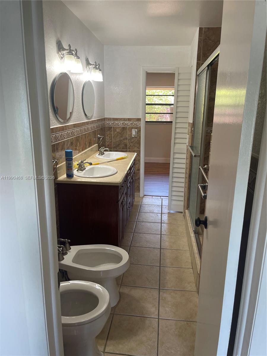 11269 Southwest 116th Terrace, Unit 11269 Miami, FL 33176 - Photo 7 of 11 a bathroom with a sink a toilet and mirror