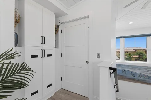 a view of a dining room and livingroom with furniture wooden floor a chandelier