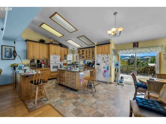 a view of a dining room with furniture a chandelier and window