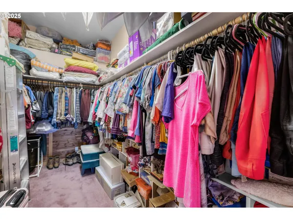 a view of walk in closet with clothes and shoes