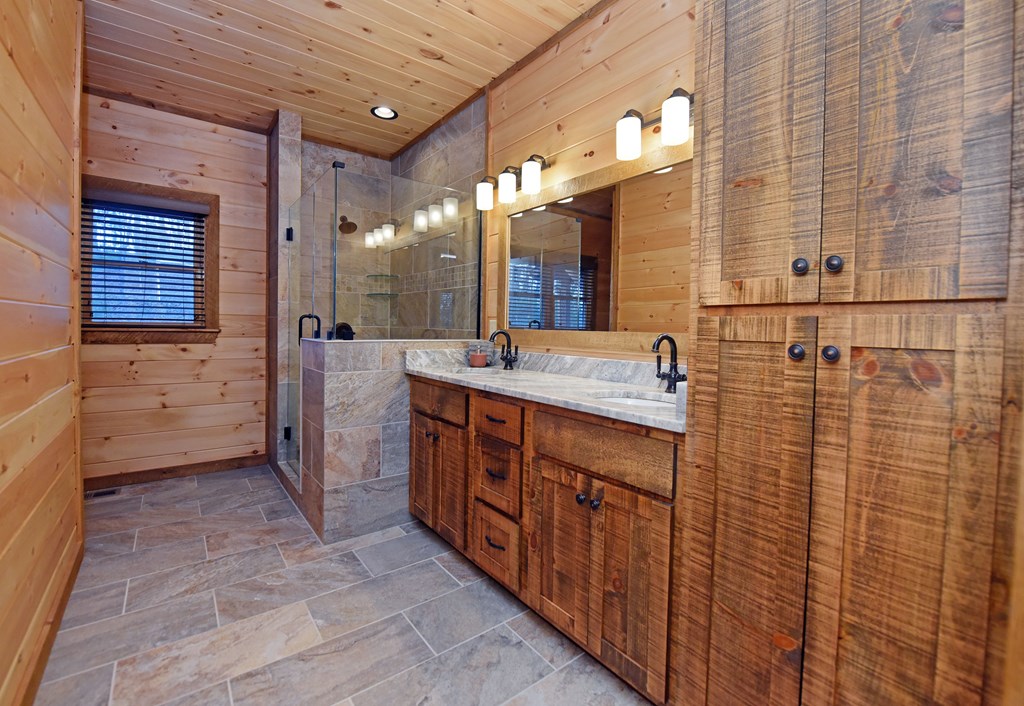 306 Native Trail Cherry Log, GA 30522 - Photo 41 of 65 a bathroom with a double vanity sink a mirror and a shower