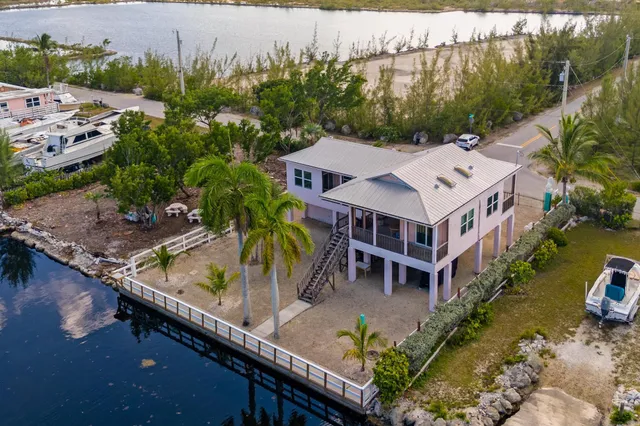 an aerial view of a house with a garden and lake view