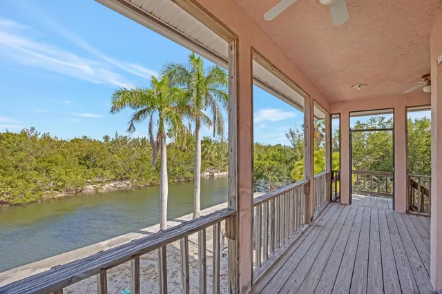 a view of a balcony with floor to ceiling windows with wooden floor