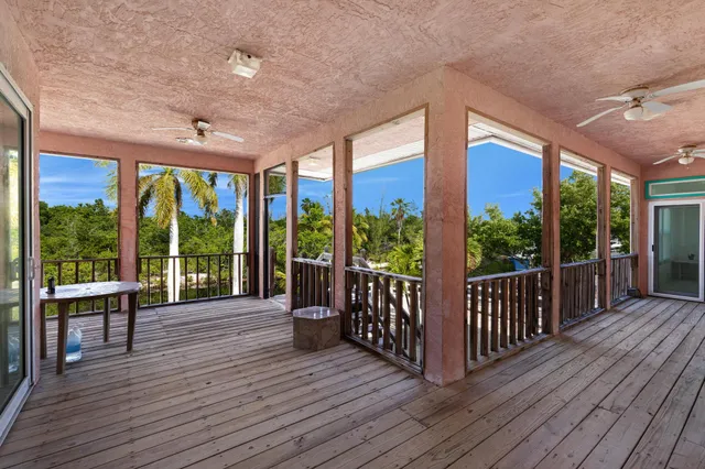 a view of a balcony with chairs and wooden floor