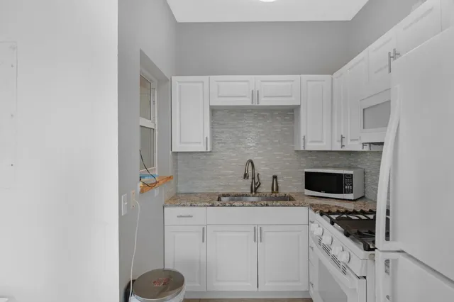 a view of a kitchen with a sink and a refrigerator