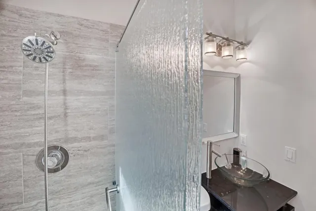 a bathroom with a sink a toilet and shower