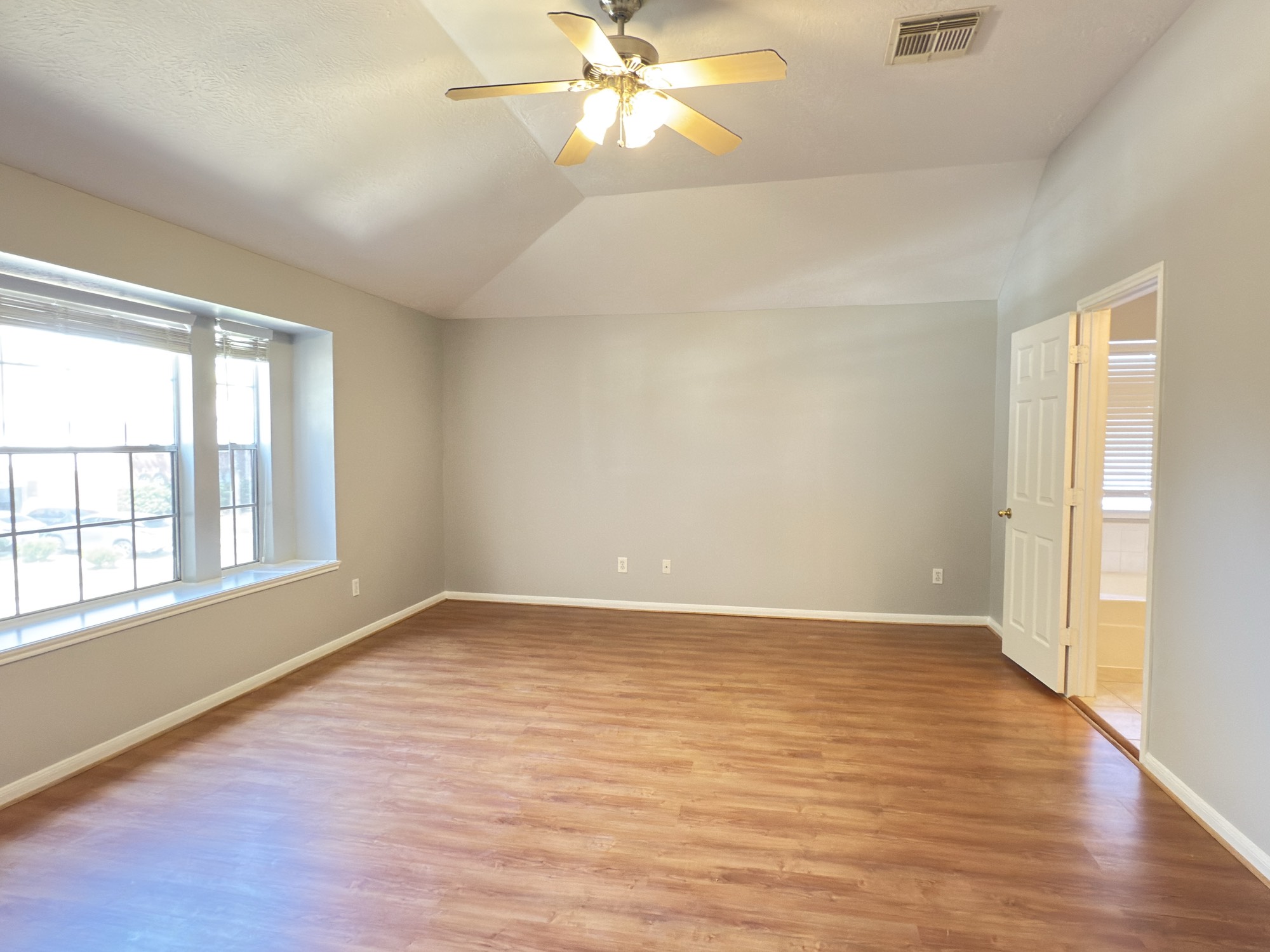 14431 Andrea Way Lane Houston, TX 77083 - Photo 12 of 20 an empty room with wooden floor fan and windows