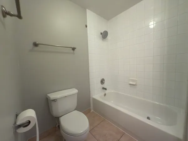 a white toilet sitting next to a bath tub