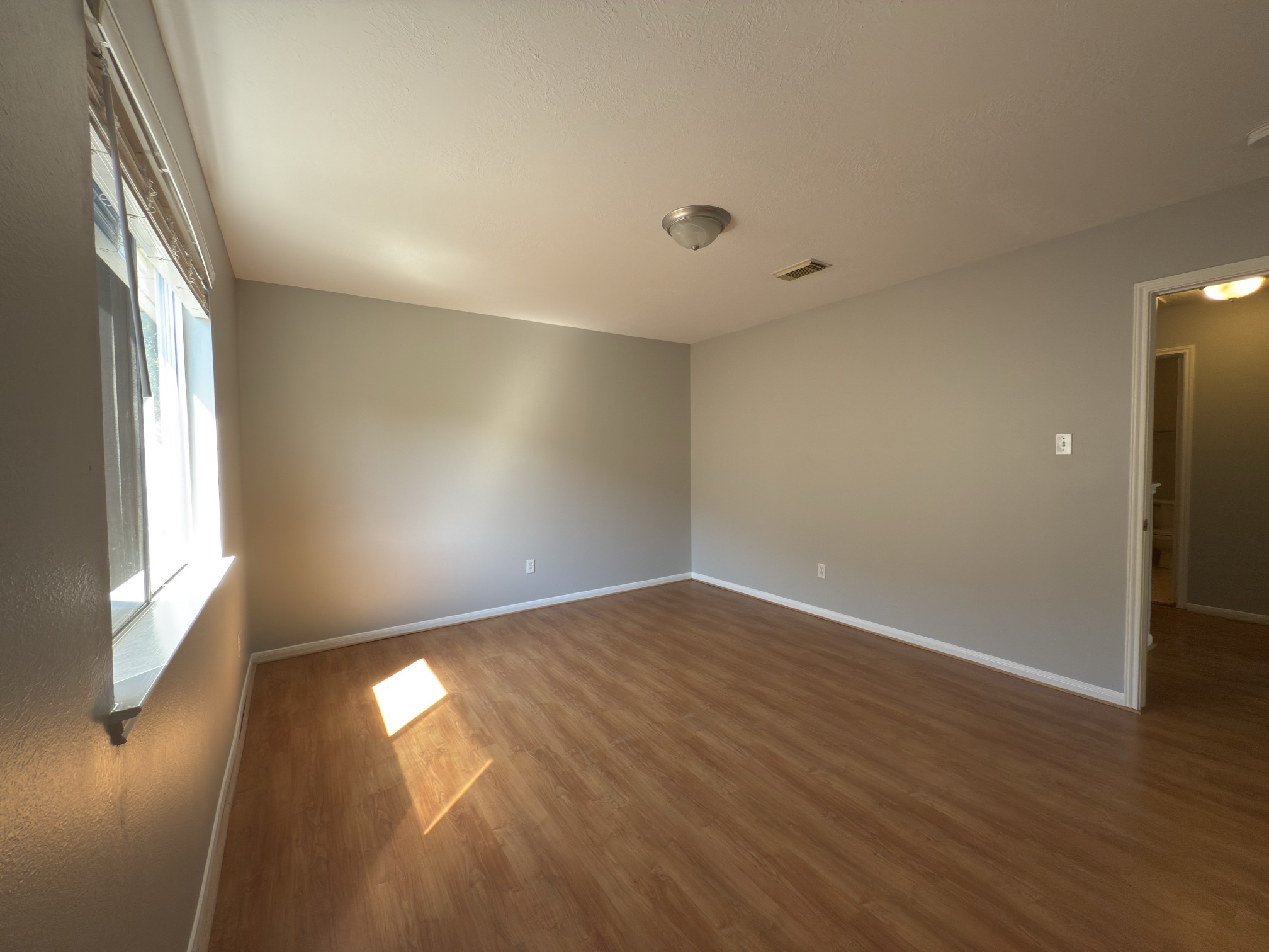 14431 Andrea Way Lane Houston, TX 77083 - Photo 18 of 20 an empty room with wooden floor and windows