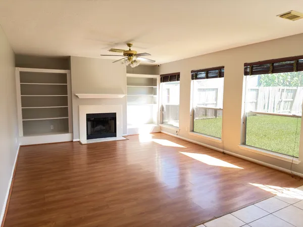 wooden floor fireplace and windows in an empty room