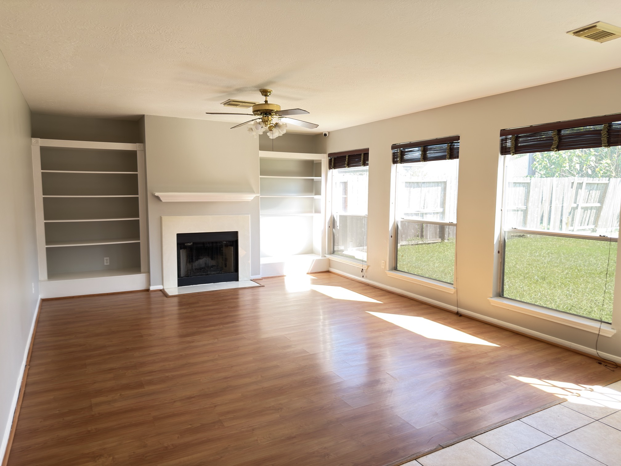 14431 Andrea Way Lane Houston, TX 77083 - Photo 4 of 20 wooden floor fireplace and windows in an empty room