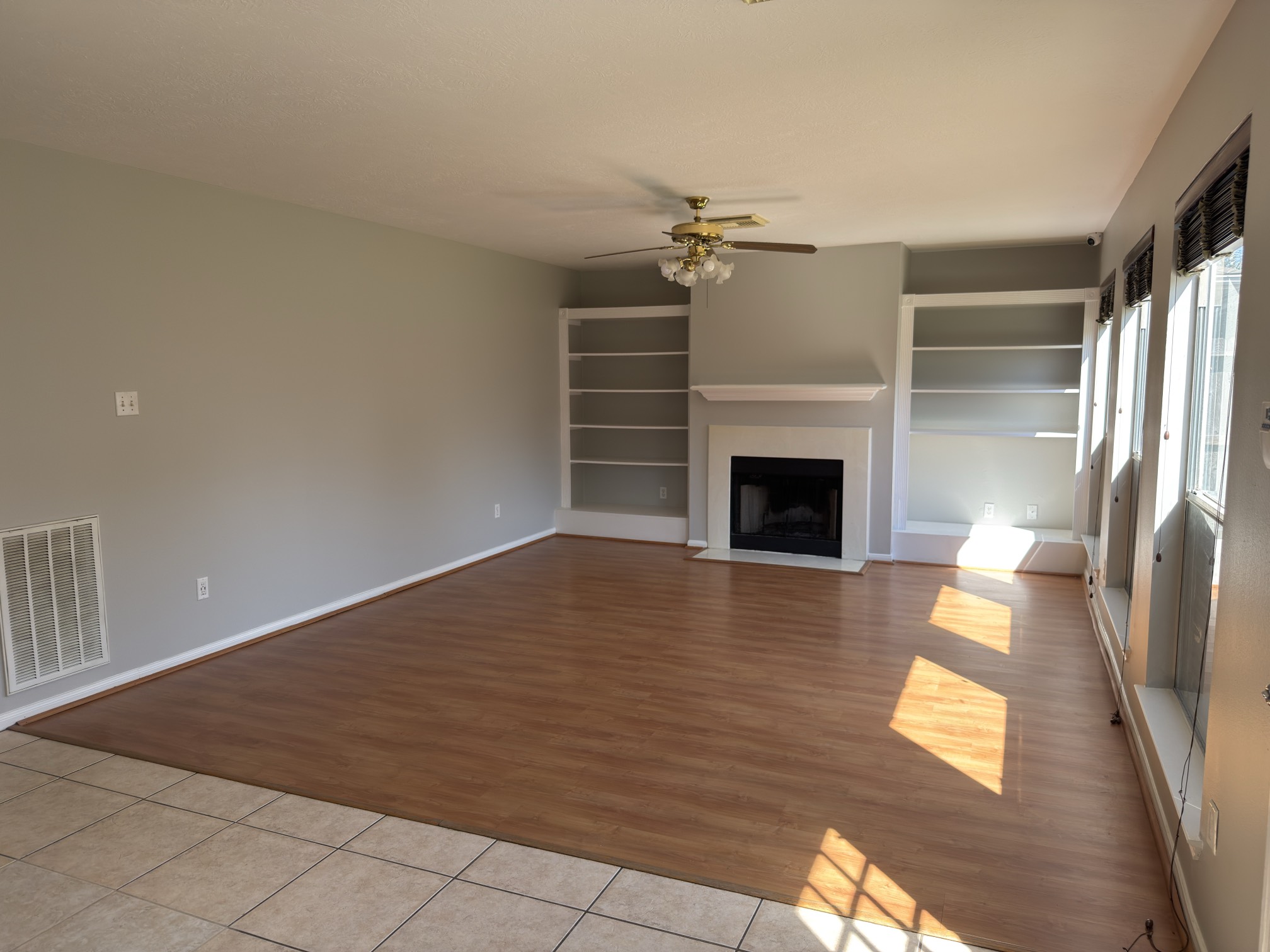 14431 Andrea Way Lane Houston, TX 77083 - Photo 5 of 20 an empty room with wooden floor fireplace and windows