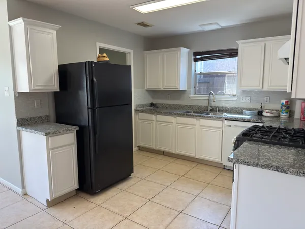 a kitchen with a refrigerator sink and cabinets
