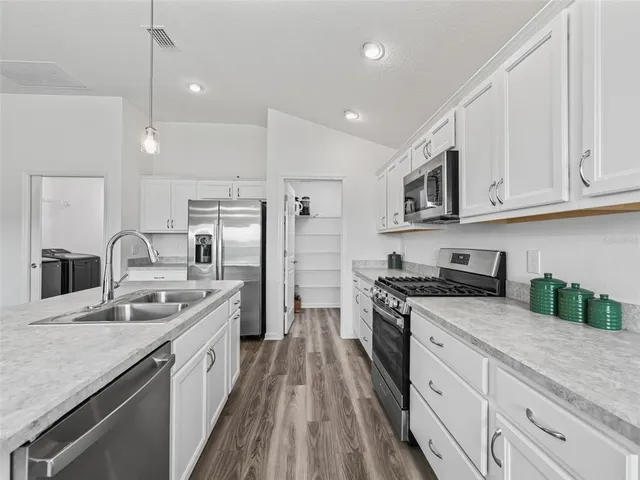 a kitchen with stainless steel appliances granite countertop a sink stove and refrigerator