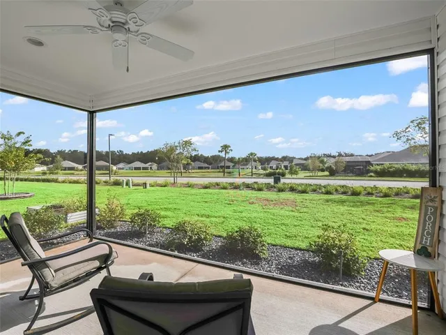 a view of a patio with lawn chairs floor to ceiling window and an ocean view