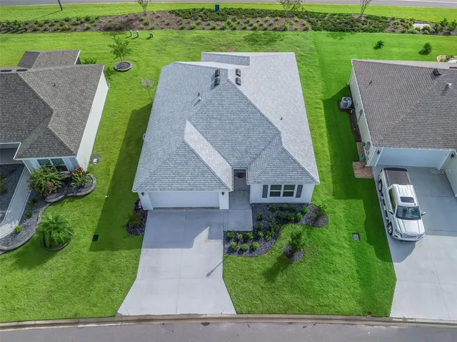 an aerial view of a house with a garden and trees