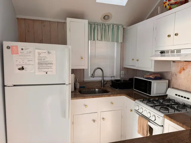 a kitchen with stainless steel appliances a refrigerator stove and white cabinets