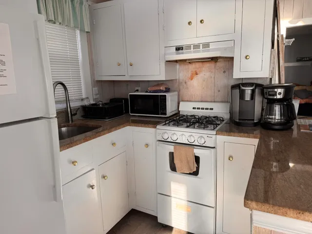 a kitchen with white cabinets and white appliances