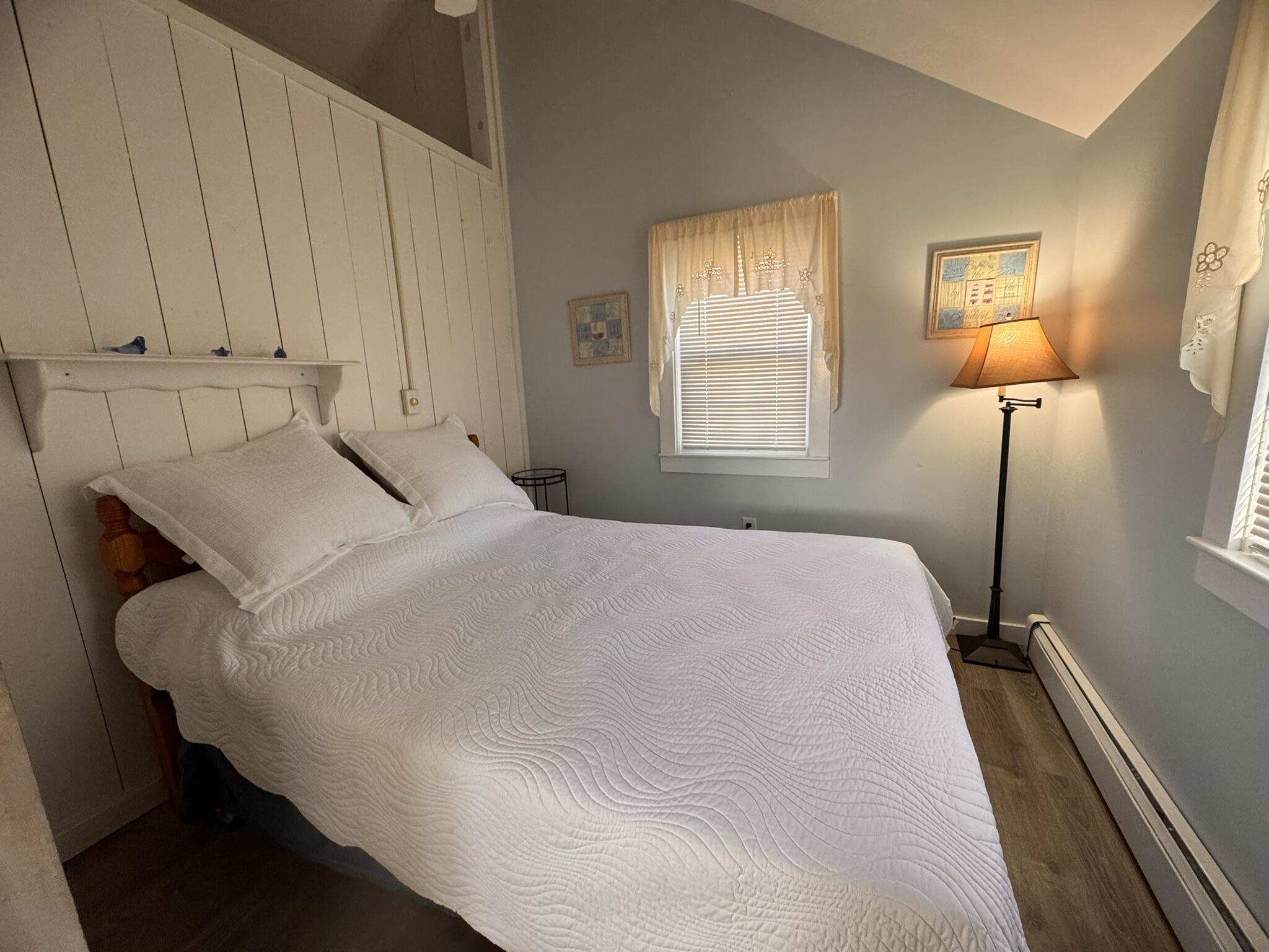 11 Brant Rock Road, Unit 11 Mashpee, MA 02649 - Photo 8 of 9 a bedroom with a bed and a lamp