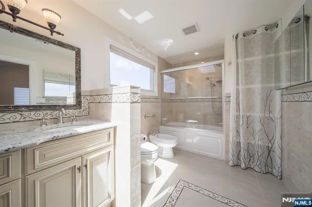 a bathroom with a granite countertop sink toilet and shower