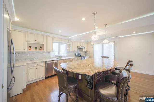 a large kitchen with kitchen island a dining table and chairs