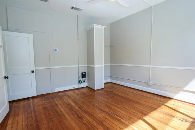 an empty room with wooden floor and white walls