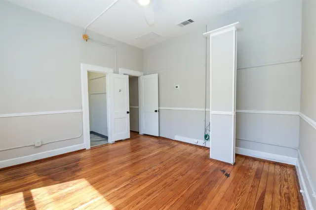 a view of empty room with wooden floor