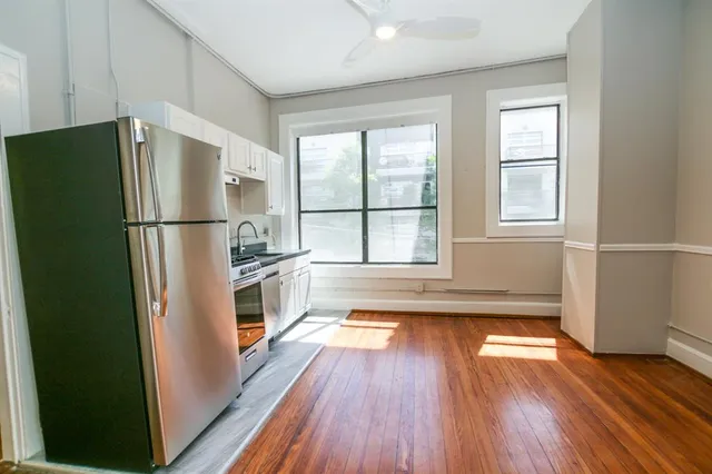 a kitchen with a refrigerator and wooden floor