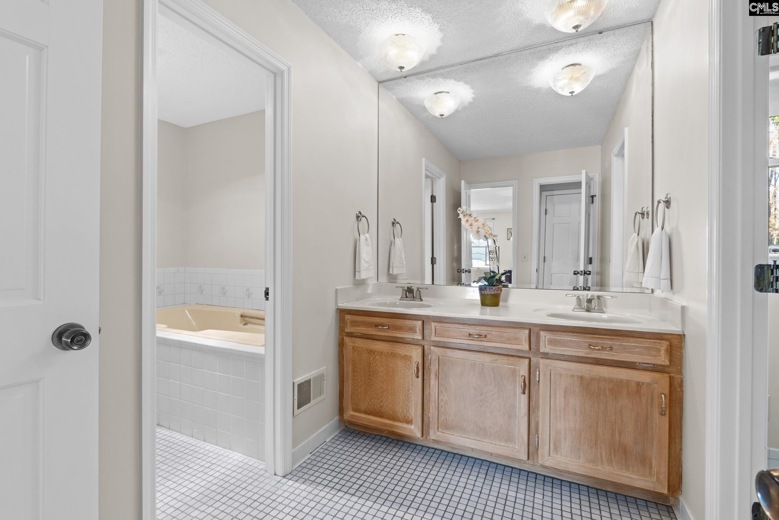 115 Rocky Ridge Road Leesville, SC 29070 - Photo 21 of 51 a spacious bathroom with a double vanity sink a mirror and a shower