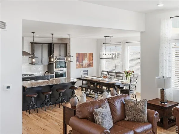 a living room with stainless steel appliances kitchen island granite countertop furniture and a large window