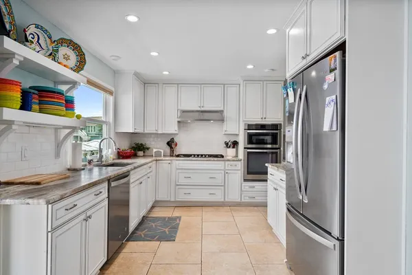 a kitchen with stainless steel appliances cabinets and a window