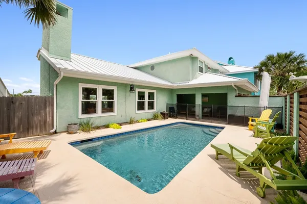 a view of a house with swimming pool and sitting area
