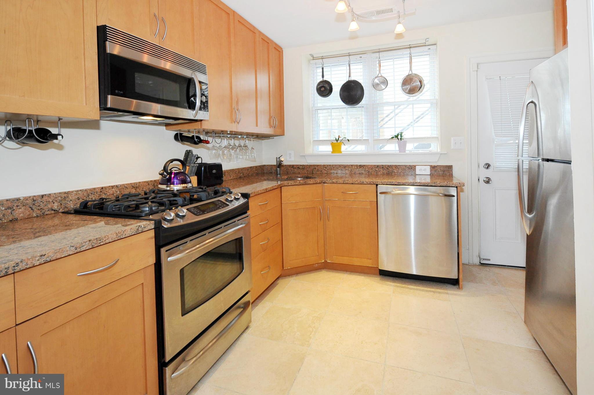 1400 Longfellow Street Northwest, Unit 101 Washington, DC 20011 - Photo 7 of 14 a kitchen with stainless steel appliances granite countertop a stove a sink and a microwave